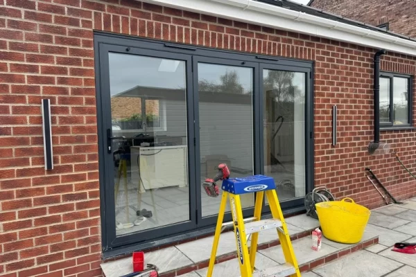 A photo of a single story home extension with outdoor lights installed.