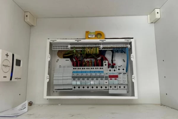 A fuse box with the lid off showing lots of cables in a tidy configuration.